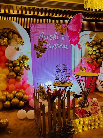 A wide shot of the butterfly-themed decor, showing how we use lighting to enhance the ambiance and make the colors of the balloons and backdrops pop.