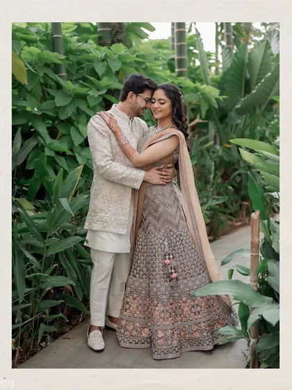 A classic full-length portrait of the couple surrounded by lush greenery. Their coordinated outfits and loving embrace create a timeless and elegant image.