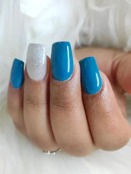 A simple yet striking manicure. This design pairs a vibrant, glossy turquoise polish with a single accent nail covered in sparkling silver glitter for a fun pop of contrast.