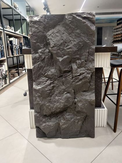 A single dark brown PU stone panel on display in our showroom. You can see the deep crevices and realistic texture that make this product so popular.