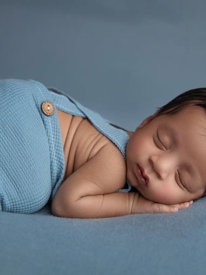 A simple and classic side pose in blue knit pants, showing off the baby's adorable back rolls.