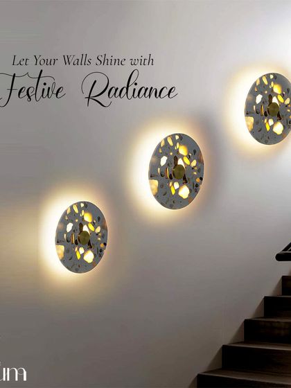 A trio of patterned, backlit wall sconces arranged along a staircase. This installation adds festive magic and a beautiful design element to a transitional space.