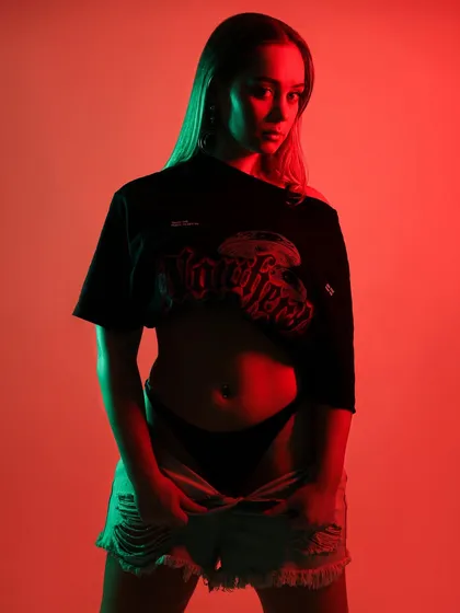 An edgy studio portrait of a dancer, illuminated with dynamic red and green colored gels to create a modern, high-energy feel. This is an example of how I use color to build a specific mood.