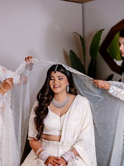 The dupatta setting is such a special tradition. Her serene smile and the delicate veil create a truly beautiful image.