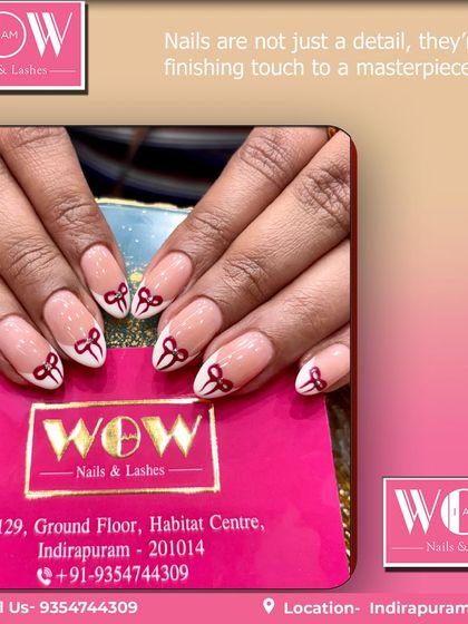 A cute and chic design featuring a modern French tip with delicate red bows. This look on almond-shaped nails is a playful twist on a classic style.