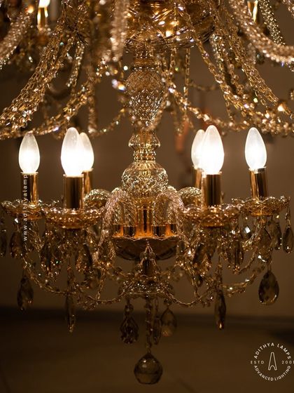 A detailed look at our magnificent multi-tiered crystal chandelier. Each arm is draped with shimmering crystal beads that reflect and refract light, creating an unparalleled sparkle. This fixture is a testament to classic European design and meticulous craftsmanship.