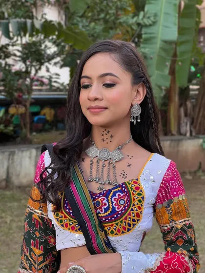 A close-up of the soft eye makeup and temporary tattoos on the neck, adding a modern touch to the traditional Navratri look.