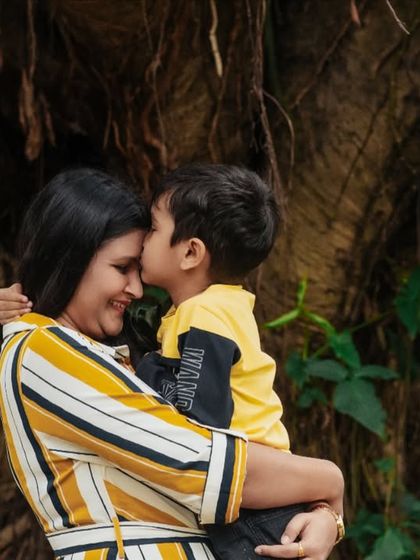 A tender kiss on the forehead. This outdoor portrait of a mother and son is filled with warmth, love, and the beauty of nature.