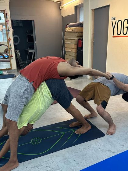 A creative and challenging three-person backbend, highlighting the strength and cooperation within our yoga community.