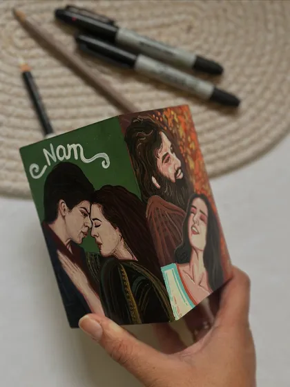 Holding the completed four-sided movie pen stand, a perfect personalized gift for a Bollywood fan.