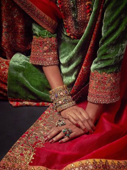 A close-up on the hands and cuffs of a Debyani & Co velvet piece, showcasing the detailed beadwork and jewelry styling.