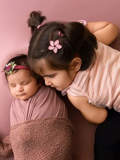 A gentle moment between an older sister and her sleeping newborn sibling. Sibling photography is a special part of my newborn sessions, capturing the start of a lifelong bond.