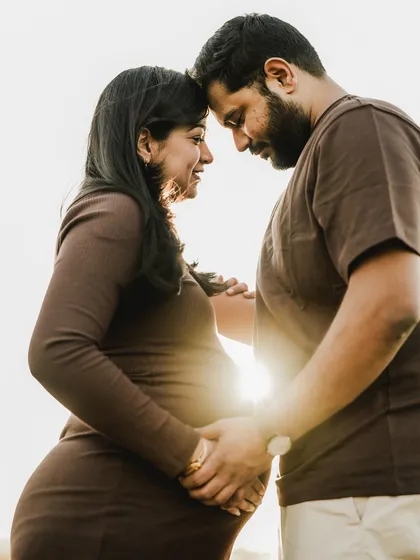 There is something truly magical about the golden hour. Here, the setting sun creates a beautiful silhouette, highlighting the deep connection between two people on the verge of parenthood. It's a quiet, intimate portrait that speaks volumes about their shared journey.