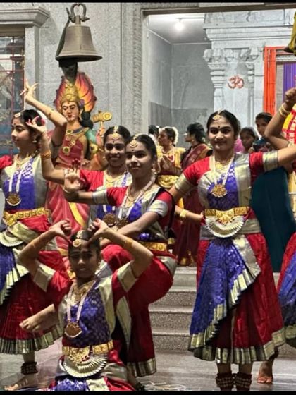 My dancers in a dynamic pose during their Navaratri program. The rich colors of their costumes stand out against the temple's stone pillars.