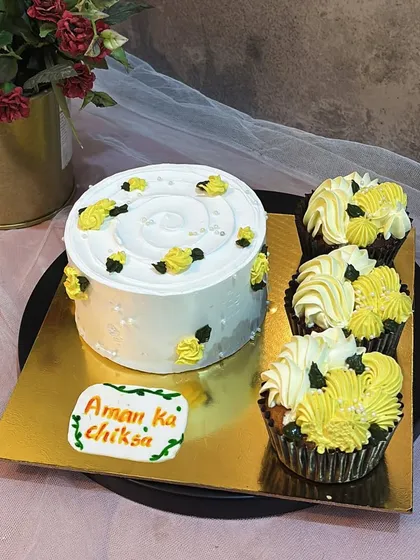 This set was for a traditional wedding event, featuring a simple white cake with yellow floral details and matching cupcakes.