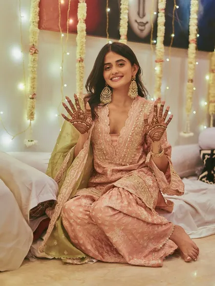 A full view of Shivvani Patil's mehendi look. Her choice of comfortable, embellished juttis allows her to sit comfortably for hours while still looking completely put-together and festive.