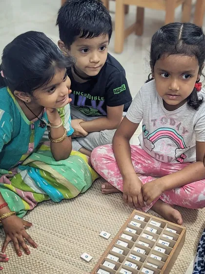Here, a group of children are captivated by the Moveable Alphabet, a cornerstone of Montessori language learning. They work together, sounding out words and discovering the magic of language in a tangible, collaborative way.