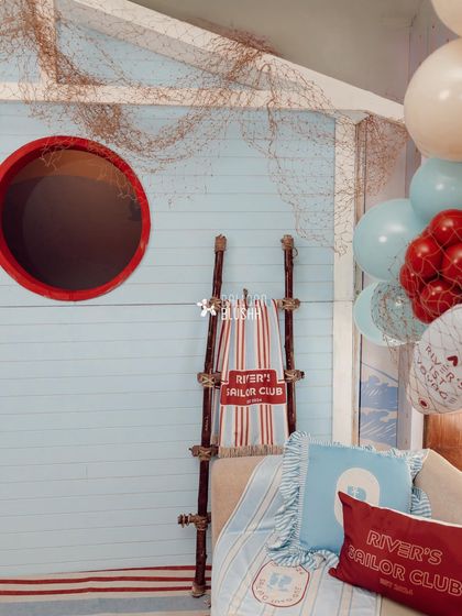 A cozy seating nook with custom-printed pillows and a personalized 'River's Sailor Club' towel.