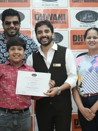 A student, his proud parents, and his teacher celebrate his artistic success.