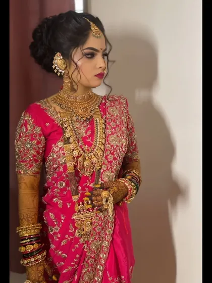 A portrait of a bride in a heavy pink embroidered saree.