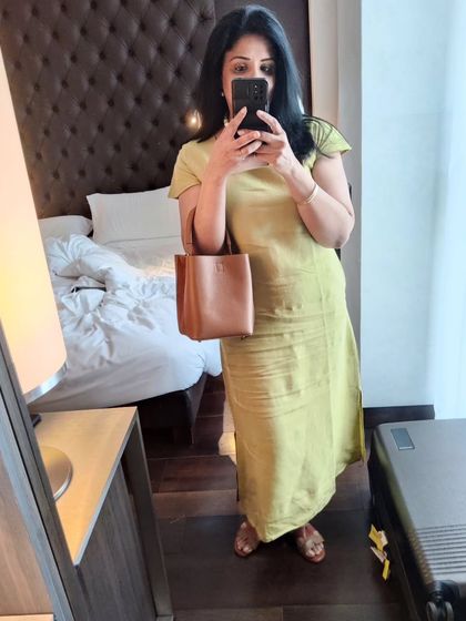 A mirror selfie in my Milan hotel room, showing the simple elegance of the olive linen dress.