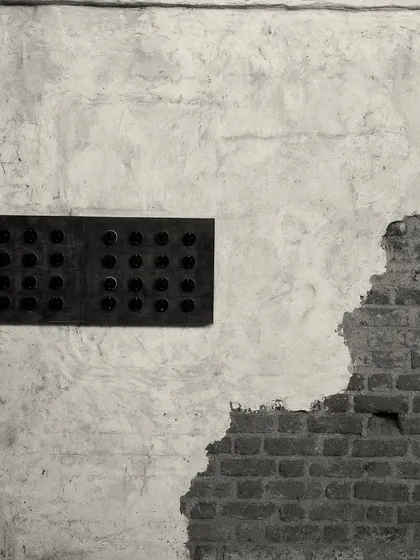 A detail of the wall treatment, where rough, exposed brick meets smooth, aged plaster. This textural contrast is a key element of the "lived-in" aesthetic.
