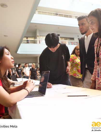 A student representative shares information about her club with interested peers and faculty at the High School Activities Mela. This event empowers students to take leadership roles and recruit new members to their groups.
