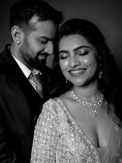 A classic and glamorous black and white close-up portrait of the couple, capturing the bride's joyful smile and the elegance of their reception look.