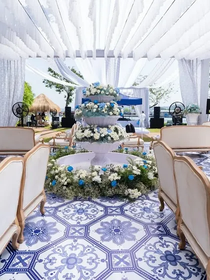 Inspired by the French Riviera, this daytime carnival setup in Goa was all about breezy elegance. The combination of a custom blue-and-white tiled floor, a flowing white canopy, and a central fountain overflowing with hydrangeas created a chic, playful, and relaxed atmosphere.