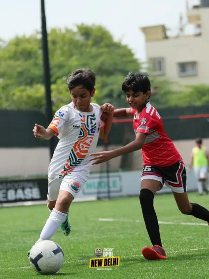 Dribbling past a defender. We teach our players the creative skills and quick thinking needed to beat opponents and create scoring opportunities.
