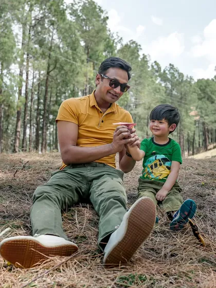 A candid father-son moment during a relaxed outdoor shoot in the woods. These are the genuine interactions that make the best memories.