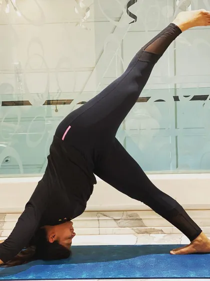 Practicing Eka Pada Adho Mukha Svanasana, or One-Legged Downward-Facing Dog. This pose deepens the stretch in the standing leg's hamstring while opening the hip of the lifted leg. It's a great way to build strength and balance.