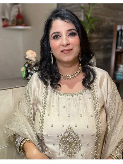 A classic and elegant party look. The makeup is soft and enhances her features, paired with simple curls for a timeless style.