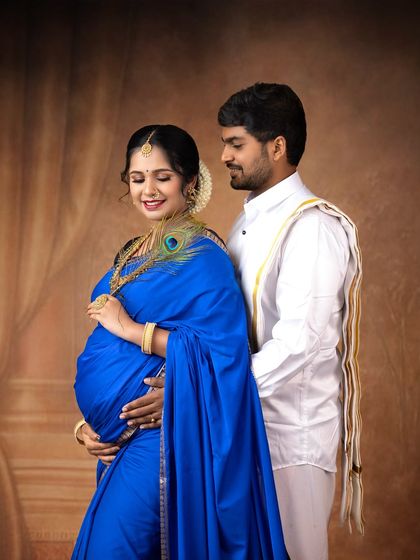 An intimate couple's portrait in traditional South Indian attire. The peacock feather is a beautiful touch, symbolizing grace and beauty, reminiscent of Lord Krishna.