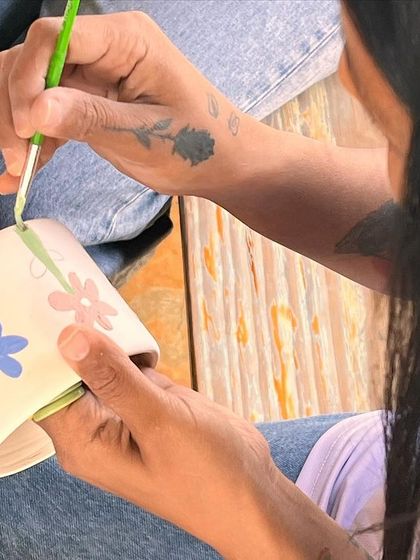 A student painting a floral design onto her mug. The final results are always a wonderful surprise.