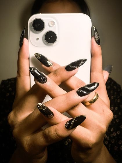 Obsessed with this new set of nails. This dark, moody, and artistic design with gold accents was created by our talented trainees.