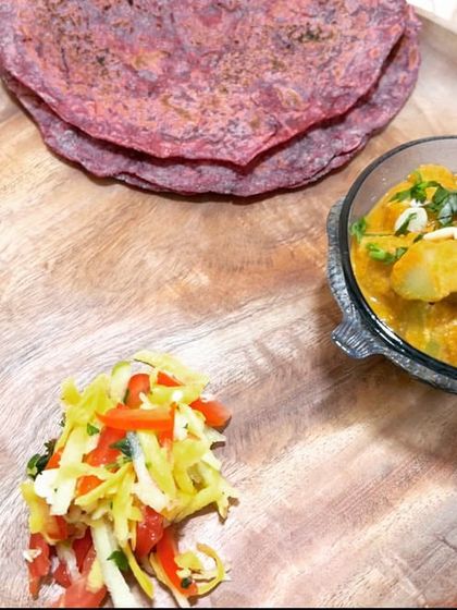 A complete satvic meal on a plate. This features my vibrant beet roti, a creamy bottle gourd curry, a fresh salad, and one of my signature 'Dates Sneaker' for a touch of sweetness.