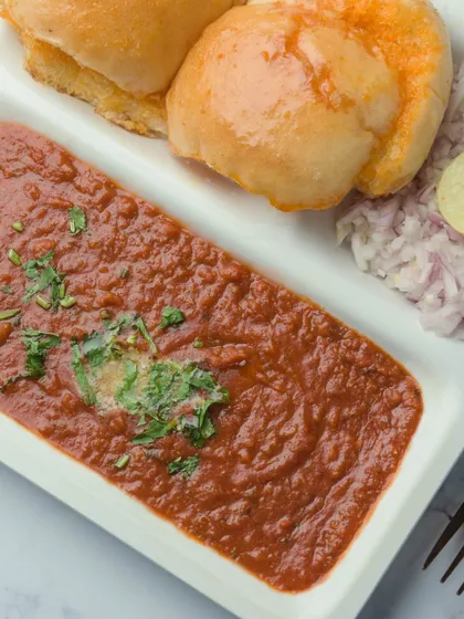 A clean, simple shot of our delicious Pav Bhaji. Served with buttery pav, chopped onions, and a slice of lemon, it's a timeless favorite for any event.
