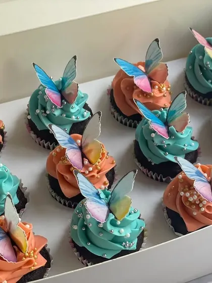 This angle shows the box of butterfly cupcakes ready for gifting. The combination of colors and the 3D effect of the butterflies make for a stunning presentation.