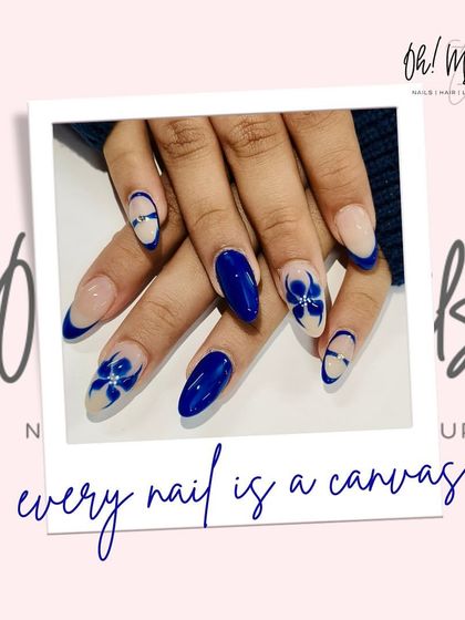 Every nail is a canvas. This design features a beautiful royal blue polish with accent nails showcasing delicate, hand-painted blue and white flowers.