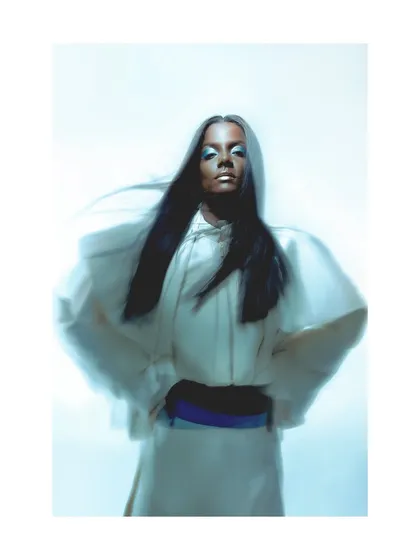 A futuristic fashion portrait with cool, blue-toned lighting. The styling features a structured white hooded garment, and I used a slow shutter speed to capture the movement of the model's hair, adding a dynamic element.