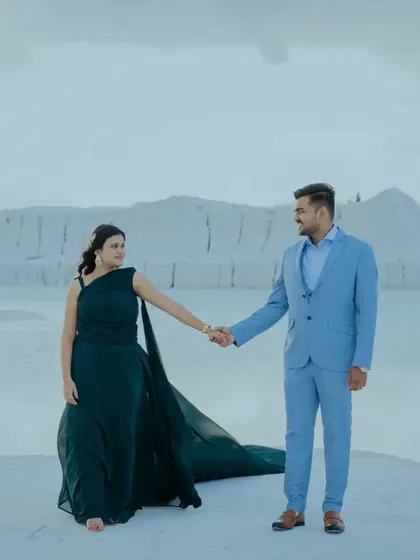 A walking shot at the Kishangarh dumping yard, where the white ground meets the blue water. The couple's modern outfits stand out against this unique and picturesque background.