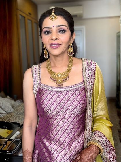 This look for a wedding guest is both soft and timeless. I used a palette of purples on the eyes to match her beautiful brocade outfit, keeping the skin fresh and the lips in a complementary mauve shade.