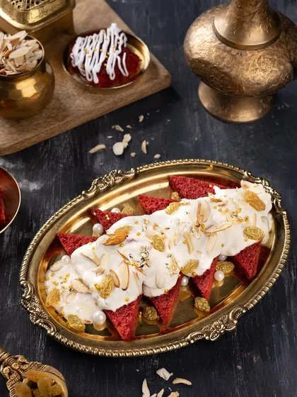 A top-down view of the Red Velvet Shahi Tukda, showcasing the rich cream, nuts, and edible pearls. This angle highlights the intricate details and textures of this fusion dessert.