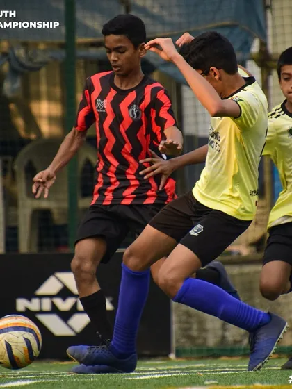 An intense moment from a Youth Championship game, with our player battling for possession against two opponents.