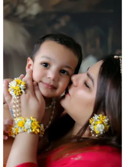 A close-up from a themed Janmashtami photoshoot, capturing a mother's affectionate kiss. I provide costumes and props to make these festive sessions special and authentic.