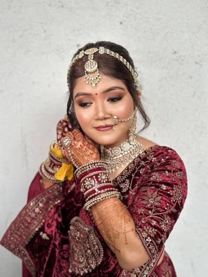 A final check before the ceremony. This image captures the intricate details of her matha patti, nath, and the soft glam makeup that completes her look.
