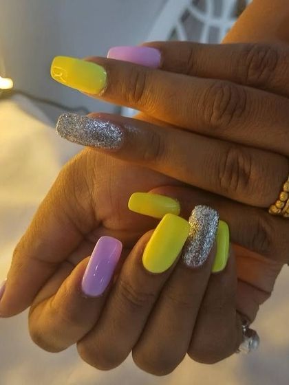 A close-up of the yellow, lilac, and silver glitter colorblock nails. I love her choice of colors.