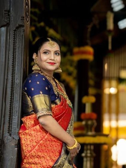 A close-up portrait of Apoorva. The rich colors of her saree and the traditional jewelry highlight her bridal glow.