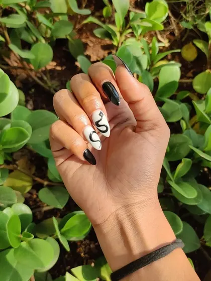 An outdoor shot of the mysterious and trendy snake-themed nails. The design looks so cool in the sunlight.
